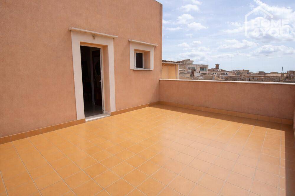 Weitläufige Dachterrasse mit Fliesenboden und Panoramablick über die Stadt.