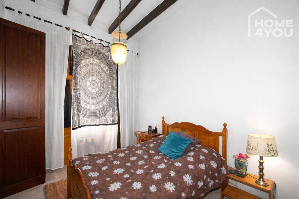 Gemütliches Schlafzimmer mit Holzbalkendecke, Einzelbett und traditioneller Einrichtung.