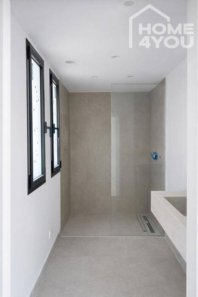 Minimalistisches Badezimmer mit ebenerdiger Dusche, schwebendem Waschtisch und Fenstern.