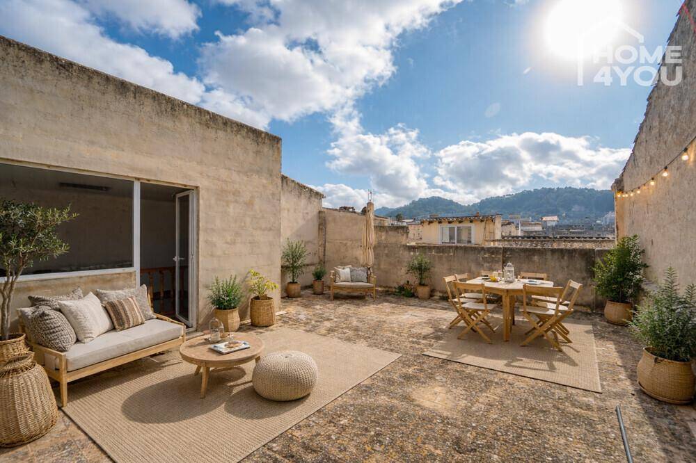 Große Dachterrasse mit Sitzgelegenheiten, Esstisch und Blick auf die umliegende Landschaft.