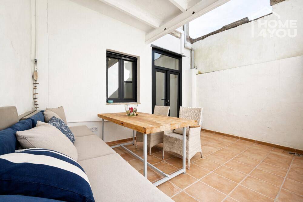 Gemütliche Terrasse mit Sitzgelegenheiten und Zugang zu einem Innenhof, ideal zum Entspannen.