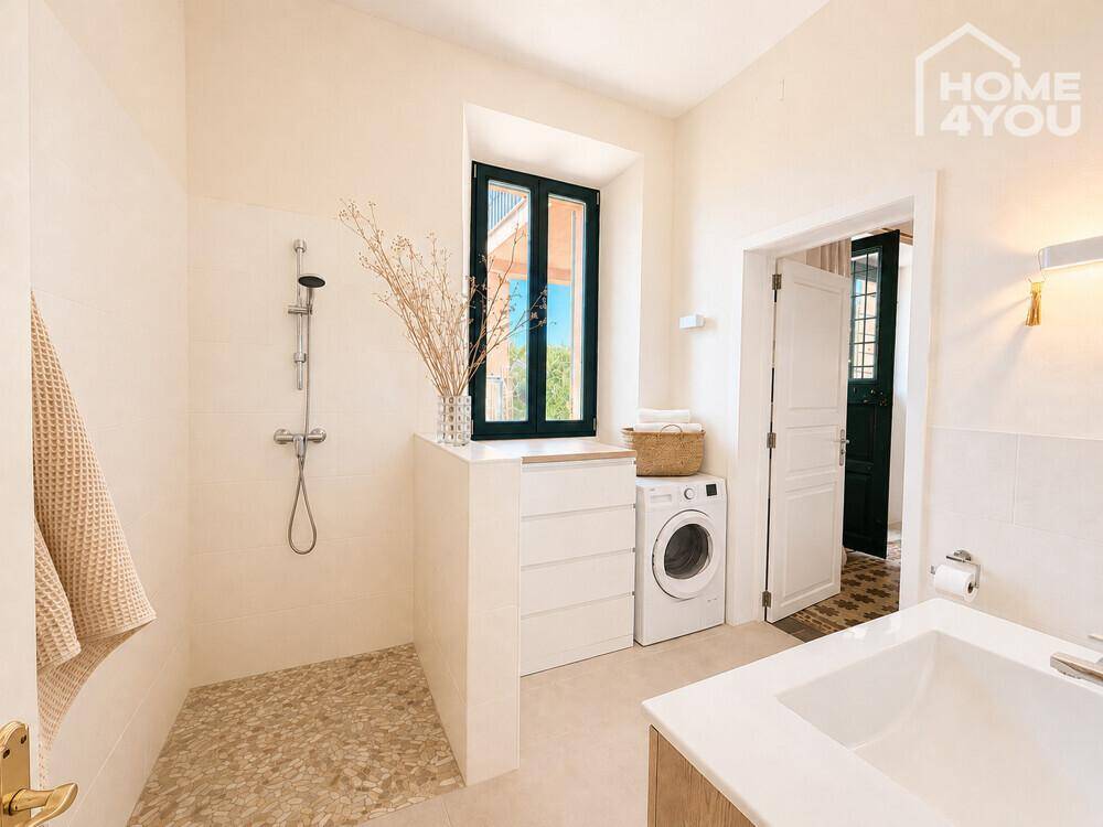 Modernes Badezimmer mit begehbarer Dusche, Waschmaschine und Fenster.