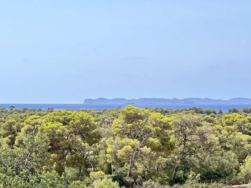 Weitläufiger Blick auf das azurblaue Meer und die Küstenlinie unter klarem Himmel.