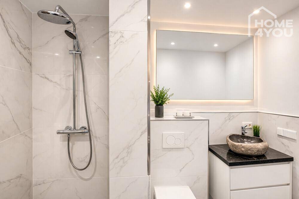 Modernes Badezimmer mit weißem Marmor, Steinsink und Duschbereich.