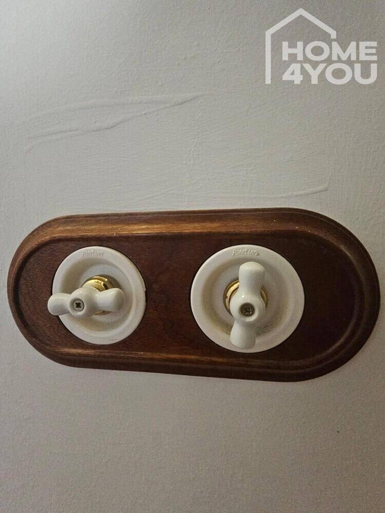 Detailaufnahme von traditionellen Lichtschaltern auf einer Holzplatte.