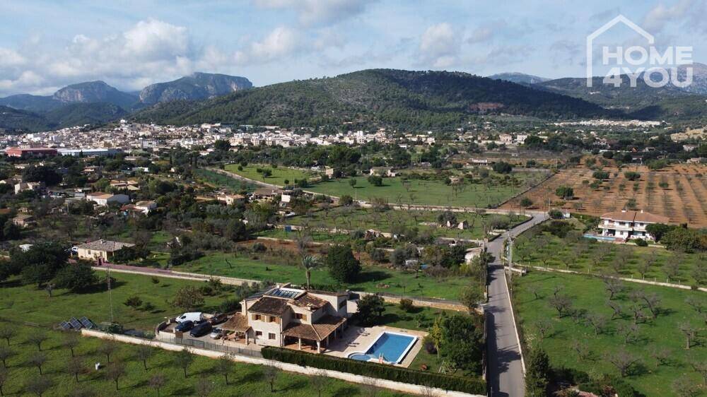 Panoramablick auf das Anwesen mit Pool, umgeben von Natur und Bergen im Hintergrund.