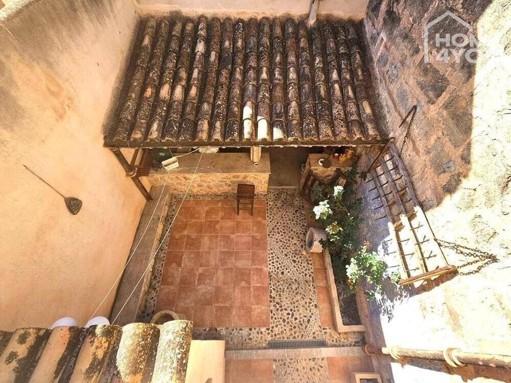 Vogelperspektive des charmanten Innenhofs mit überdachter Bar und traditionellen Fliesen.