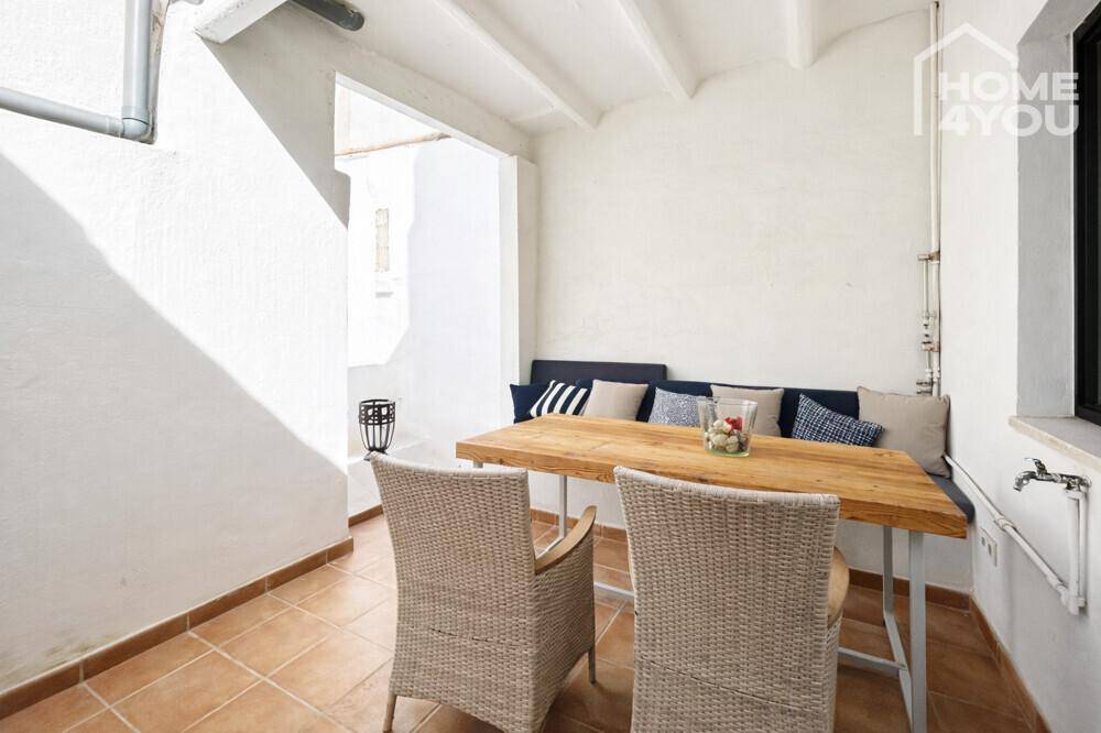 Überdachte Terrasse mit Holztisch und Sitzbank, ideal für Mahlzeiten im Freien.