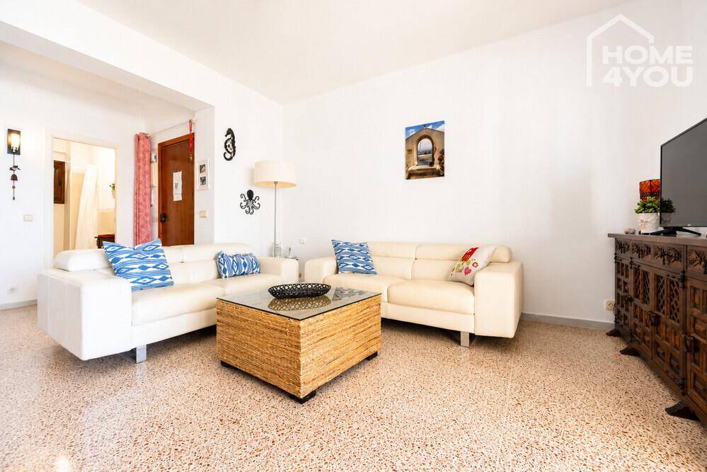 Gemütliches Wohnzimmer mit hellen Sofas, Couchtisch und dekorativen Elementen.
