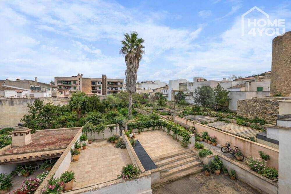 Mehrere Terrassen und ein weitläufiger Gartenbereich mit Palmen und mediterraner Vegetation.