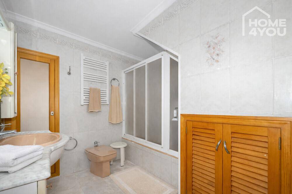 Badezimmer mit Dusche, Bidet, Marmorwaschtisch und beheiztem Handtuchhalter.