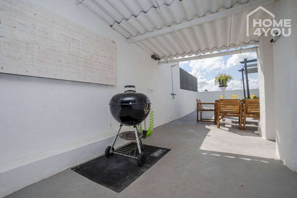 Überdachte Terrasse mit Grillbereich und Esstisch im Freien für gesellige Stunden.