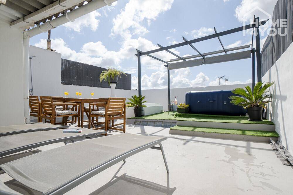 Geräumige Dachterrasse mit Liegestühlen und Essbereich, perfekt zum Sonnenbaden und Entspannen.
