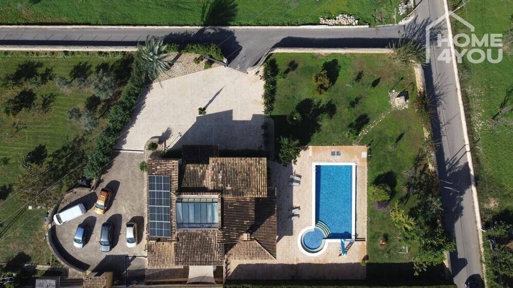 Vogelperspektive des Hauses mit Poolbereich, Zufahrt und Solaranlage auf dem Dach.