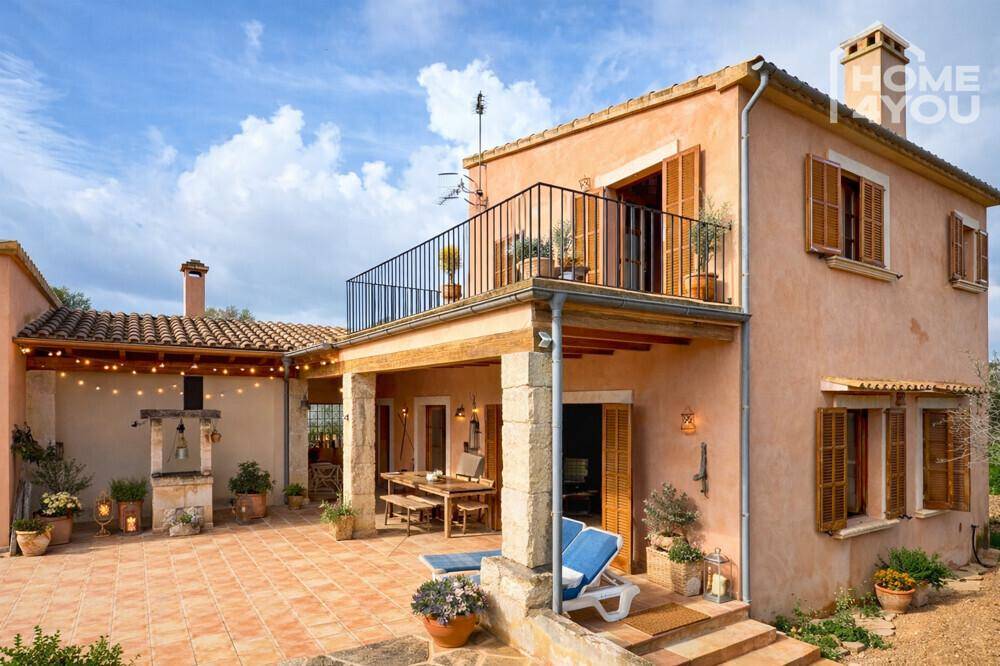 Charmantes Landhaus mit großer Terrasse, Balkon und Außenküche unter mediterranem Himmel.