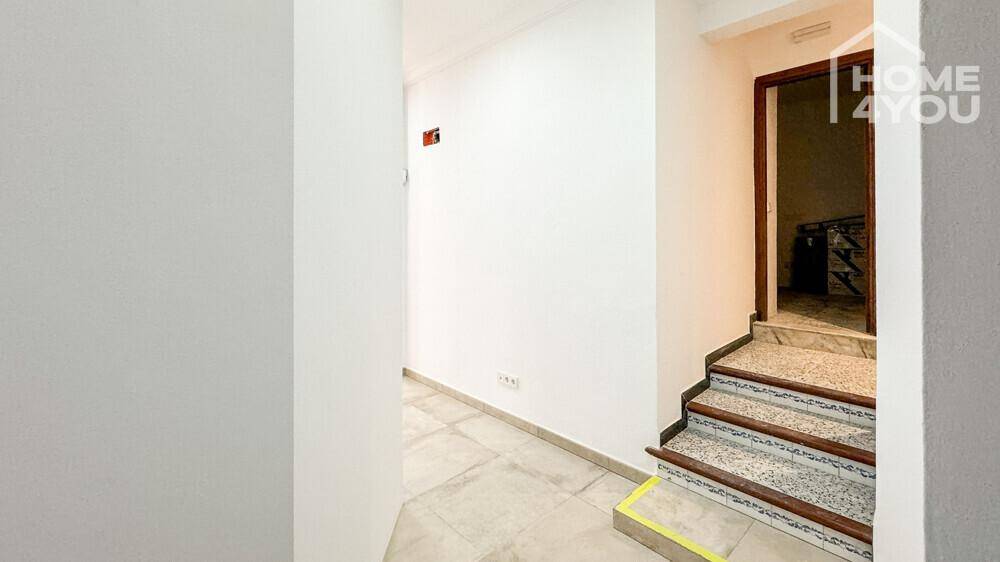 Heller Flur mit Treppenaufgang und Fliesenboden, führt zu weiteren Räumen im Obergeschoss.