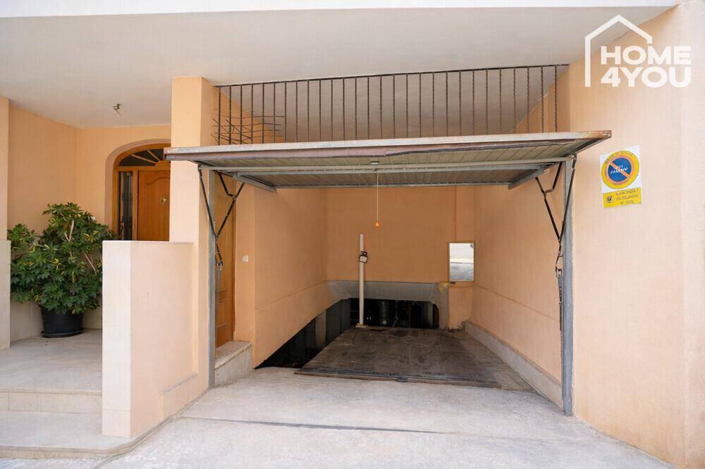 Eingang zu einer Tiefgarage mit geöffnetem Garagentor, bietet sicheren Parkplatz.