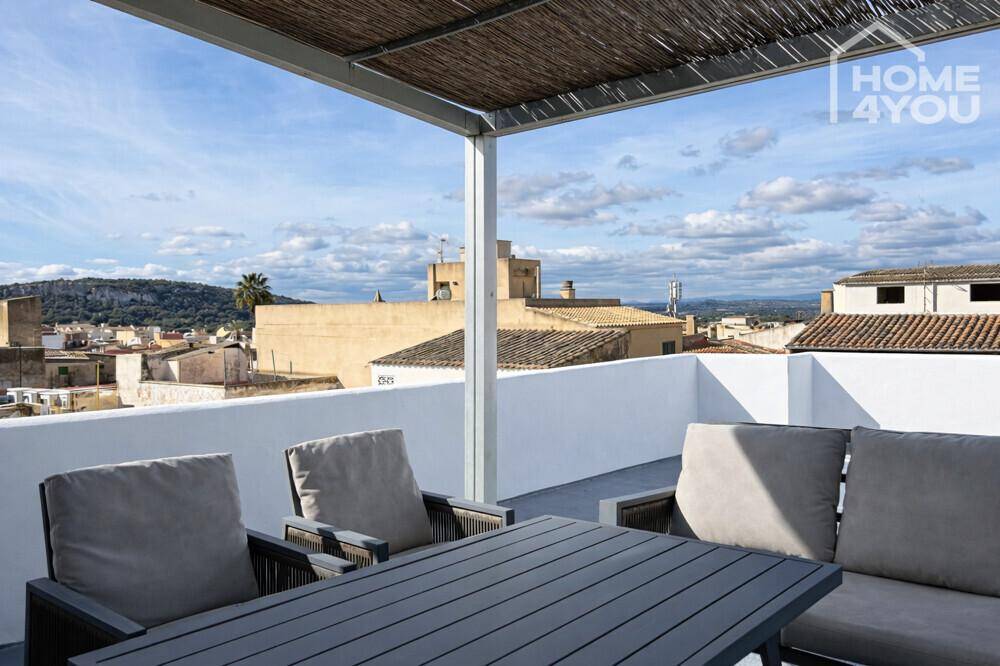 Geräumige Dachterrasse mit Loungemöbeln und weitem Blick über die Dächer der Stadt.