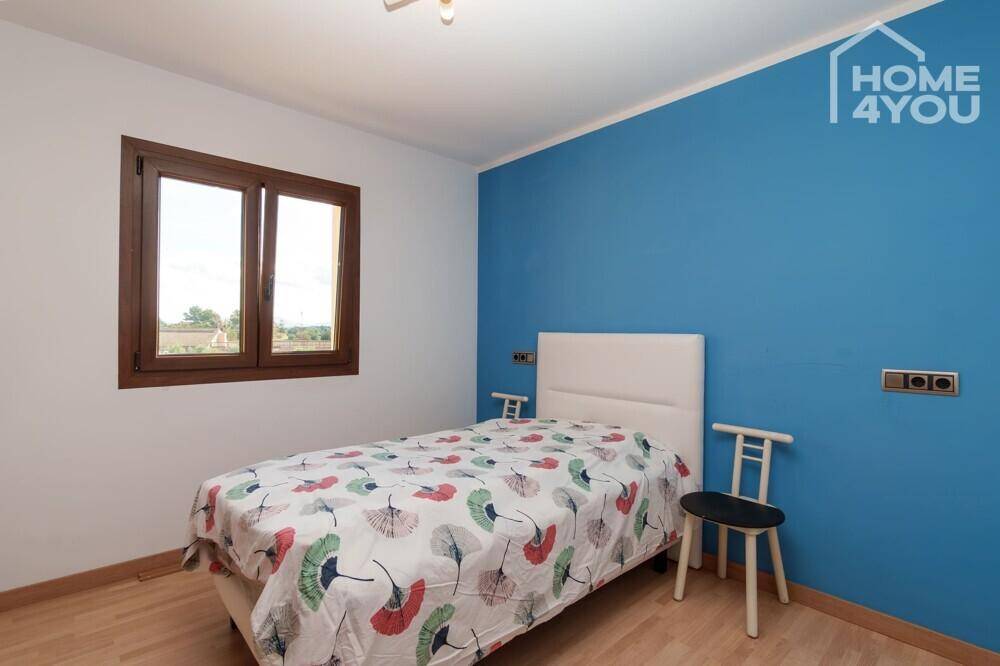 Kinderzimmer oder Gästezimmer mit Einzelbett und einer auffälligen blauen Akzentwand.