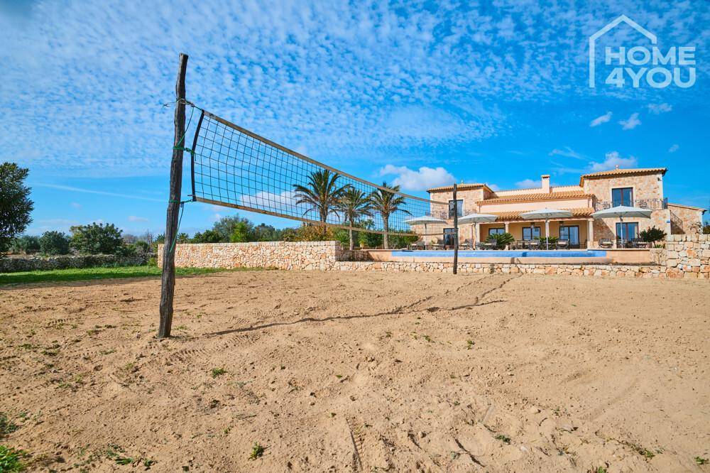 Sandiger Volleyballplatz im weitläufigen Garten der mediterranen Villa.