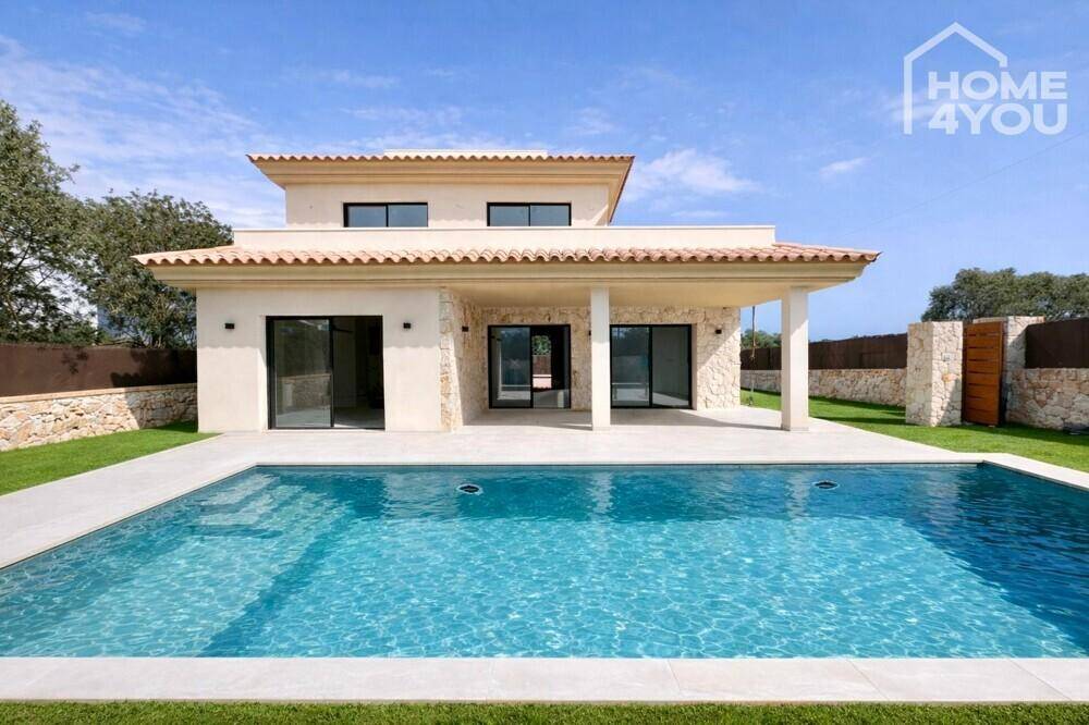 Elegante Villa mit großem Poolbereich und mediterraner Steinmauer im Garten.