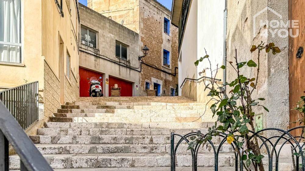Historische Steintreppe in einer engen Gasse mit traditionellen Gebäuden.