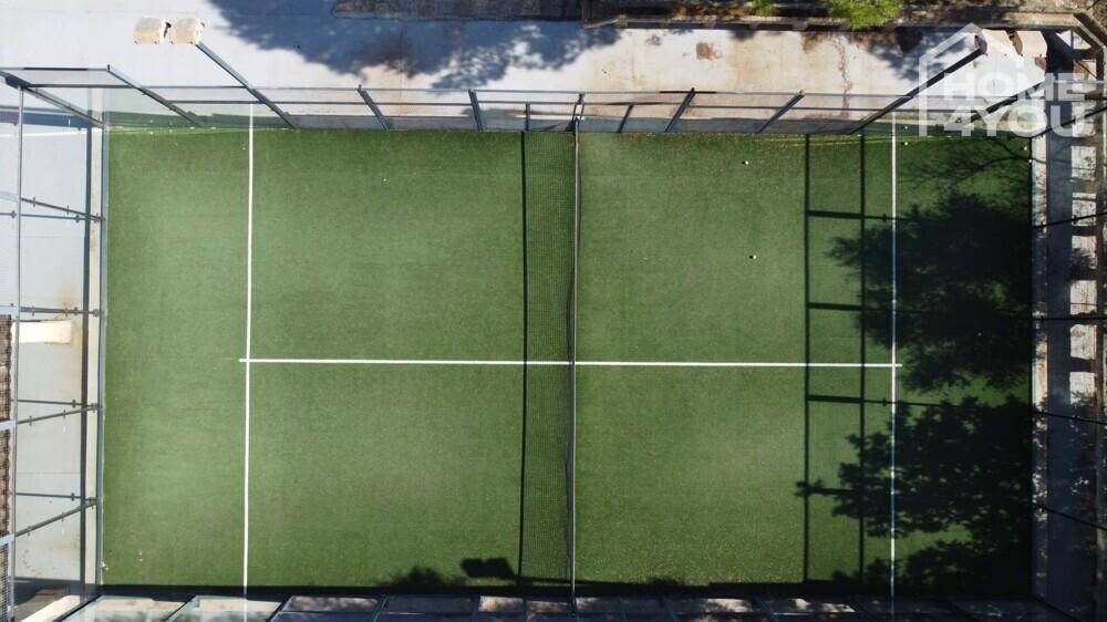 Draufsicht auf den Tennisplatz mit klaren Linien und grüner Oberfläche.