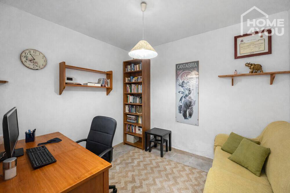 Helles Arbeitszimmer mit Schreibtisch, Bücherregal und einem Sofa für entspannte Momente.