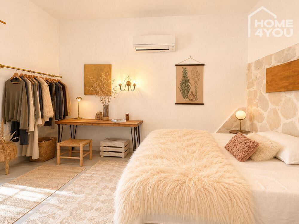 Helles Schlafzimmer mit Klimaanlage, Kleiderstange und Steinwandakzent.