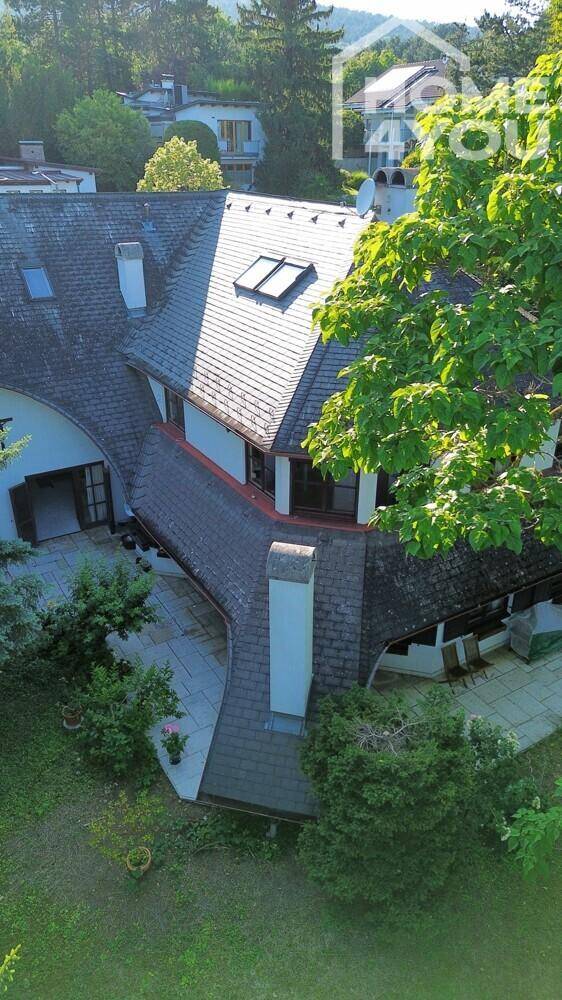 Dachansicht des Hauses mit Gaubenfenstern und umliegendem Gartenbereich.