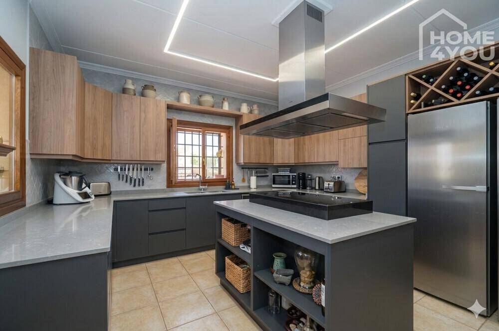 Moderne Küche mit grauen und holzfarbenen Schränken, Kochinsel und integrierten Geräten.