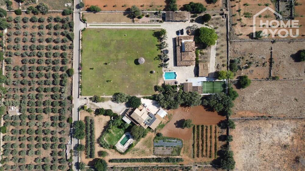 Gesamtansicht des Anwesens von oben mit großem Garten, Pool und Tennisplatz.