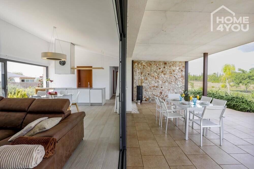 Offener Wohnbereich mit Zugang zu einer überdachten Terrasse, ideal für Mahlzeiten im Freien.