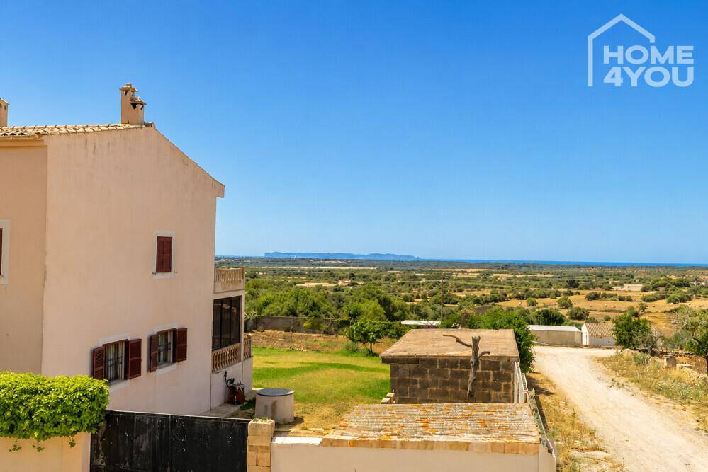 Außenansicht eines Hauses mit weitem Blick über die ländliche Umgebung bis zum Meer.