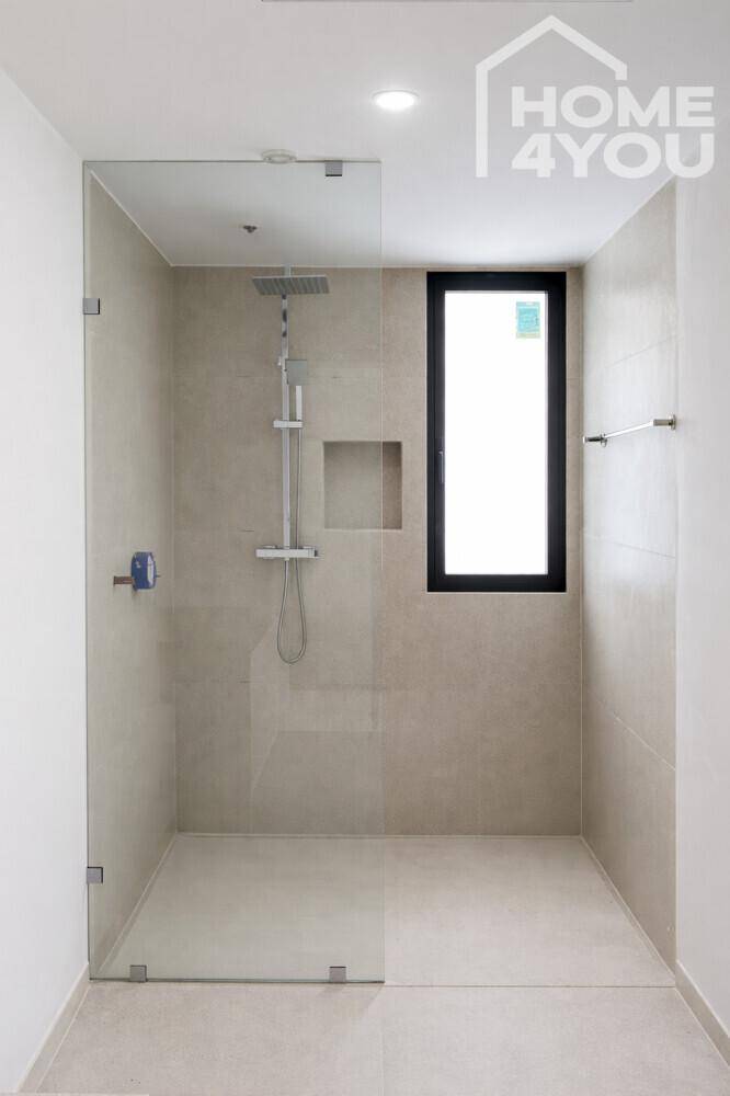 Modernes Badezimmer mit ebenerdiger Dusche, Glasabtrennung und Fenster.