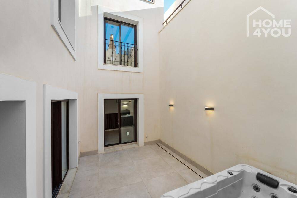 Geräumiger Außenbereich mit Whirlpool und französischem Balkon im Obergeschoss, sehr einladend.