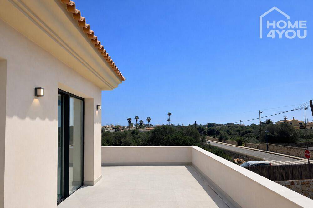 Sonniger Terrassenbereich mit Blick auf die Straße und die umliegende Landschaft.