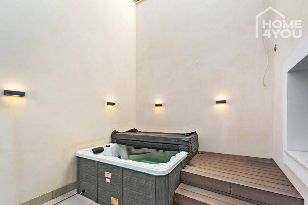 Terrassenbereich mit Whirlpool und Holzdeck, perfekt für entspannte Stunden im Freien.