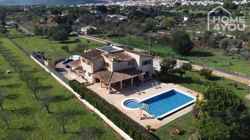 Luftaufnahme eines Landhauses mit Pool, Whirlpool und weitläufiger grüner Umgebung.