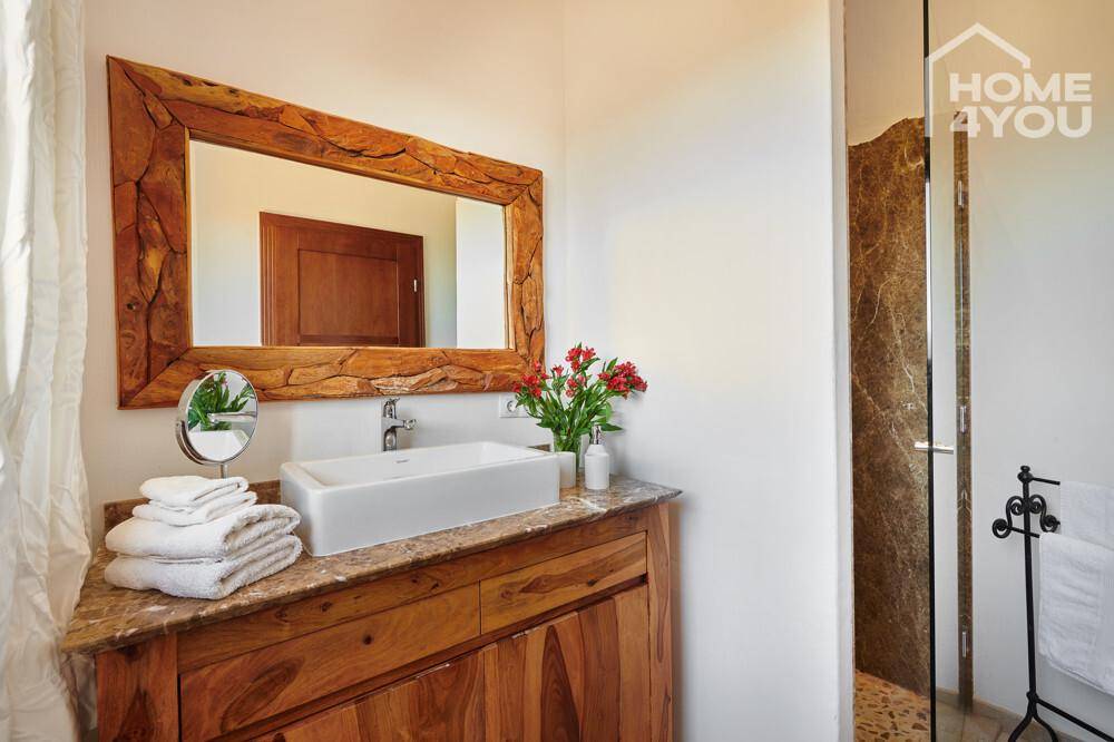 Elegantes Badezimmer mit Holzwaschtisch, Aufsatzwaschbecken und begehbarer Dusche.