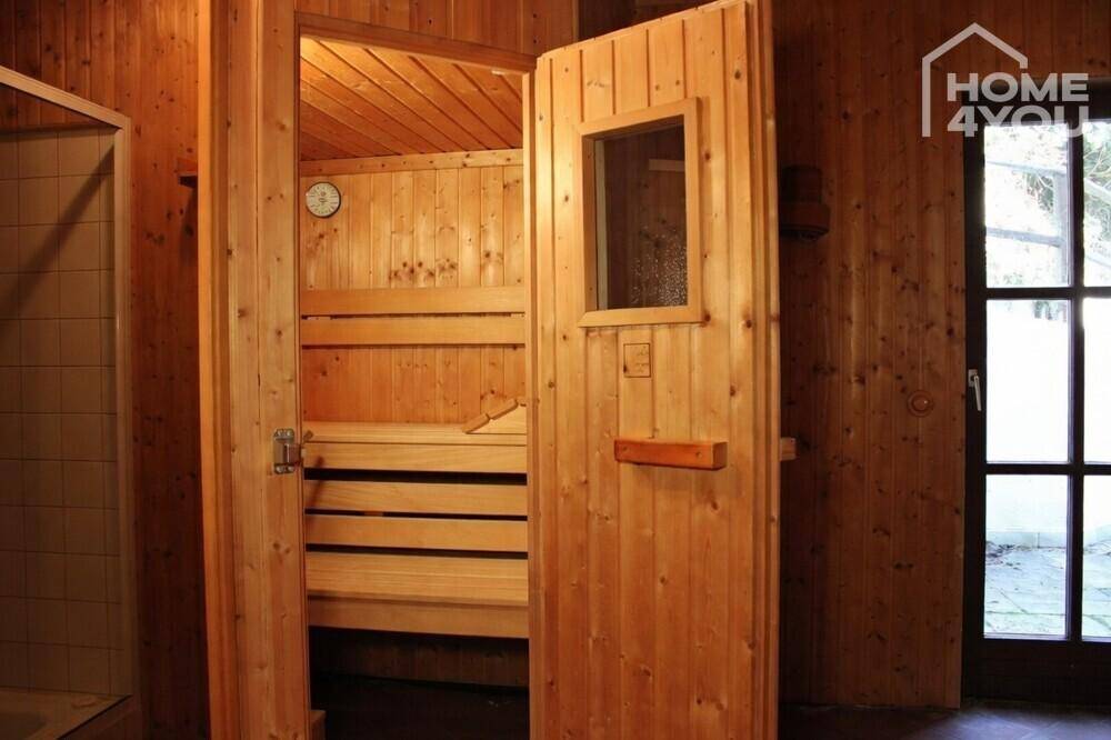 Helle Holzsauna mit Bänken und Fenster, bereit zur Nutzung.
