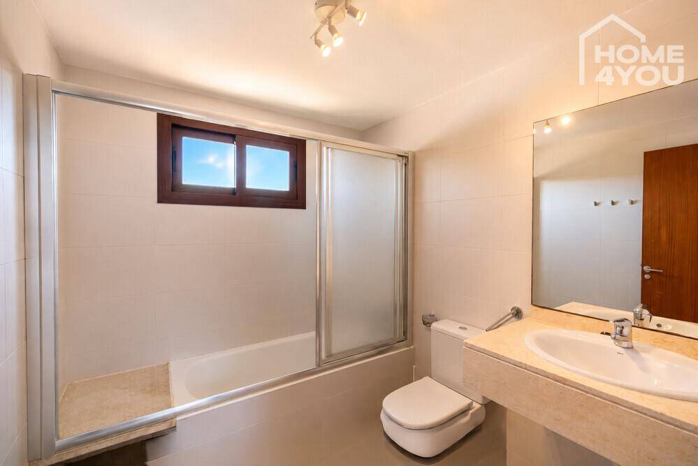 Badezimmer mit Badewanne, WC, Waschbecken und Fenster für natürliche Belüftung.