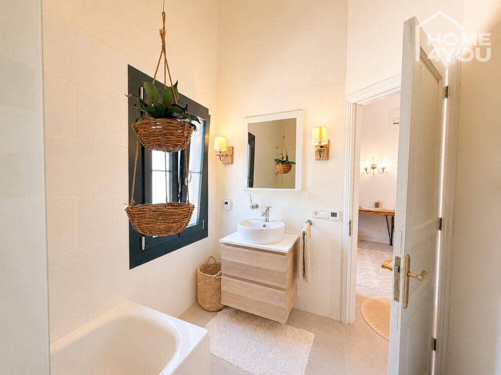 Modernes Badezimmer mit Waschbecken, Spiegel und Blick in den Flur.