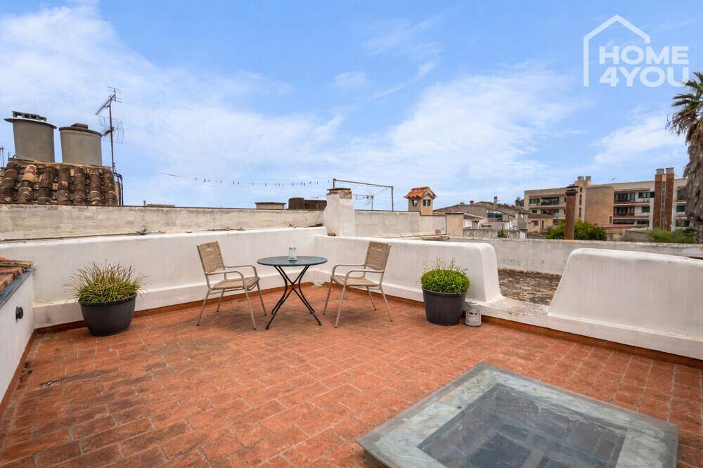 Dachterrasse mit Ziegelboden, Sitzgelegenheiten und weitem Blick über die Dächer der Stadt.