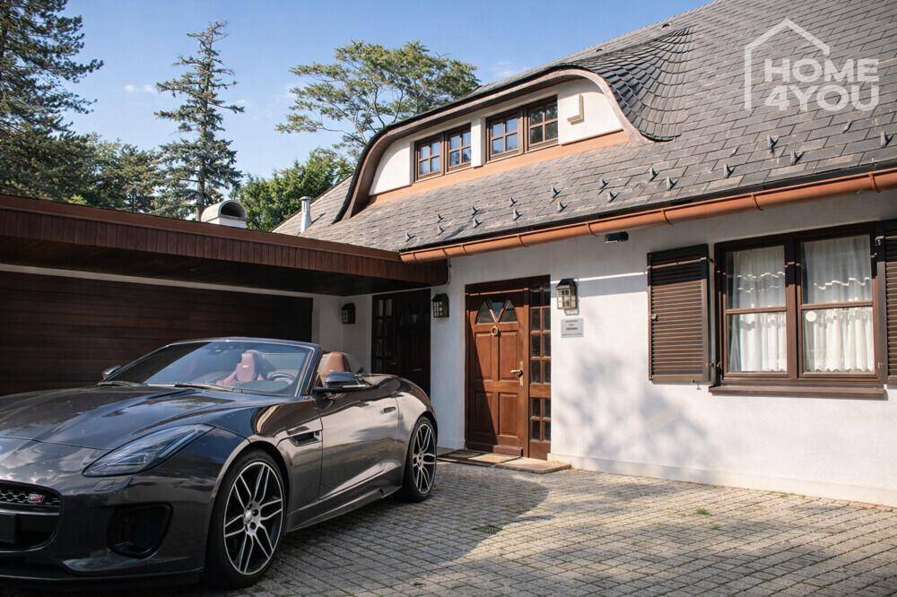 Eingangsbereich des Hauses mit gepflasterter Auffahrt und einem Sportwagen davor.