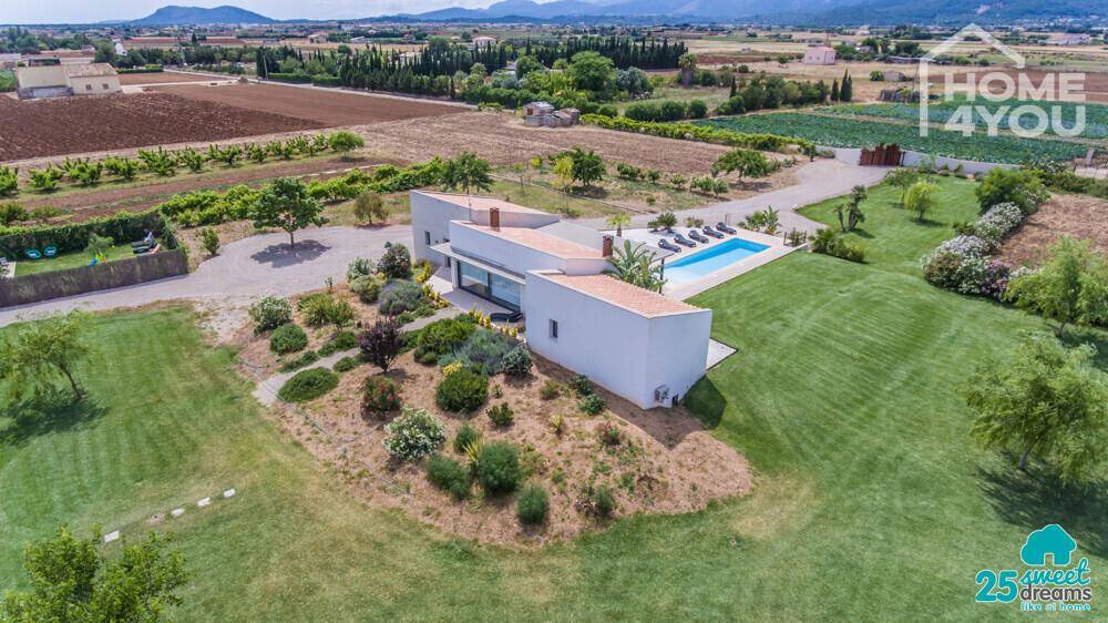 Luftaufnahme der modernen Villa mit minimalistischer Architektur und mediterran gestalteten Gärten.