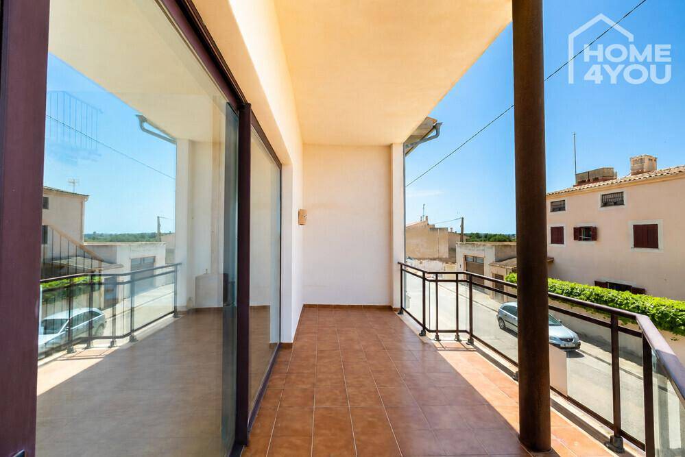 Überdachter Balkon mit Fliesenboden und Blick auf die Straße und umliegende Gebäude.