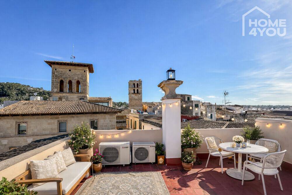 Geräumige Dachterrasse mit Sitzgelegenheiten, Pflanzen und Panoramablick über die Stadt.