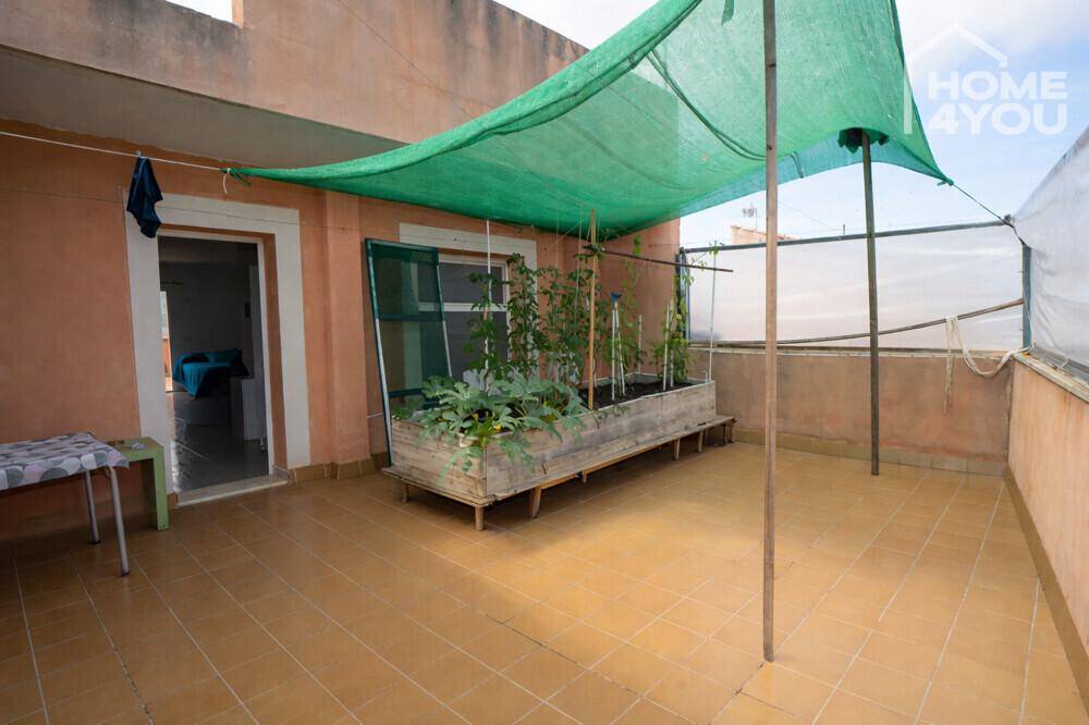Dachterrasse mit Fliesenboden, Hochbeet und Sonnenschutz, ideal für den Anbau von Pflanzen.