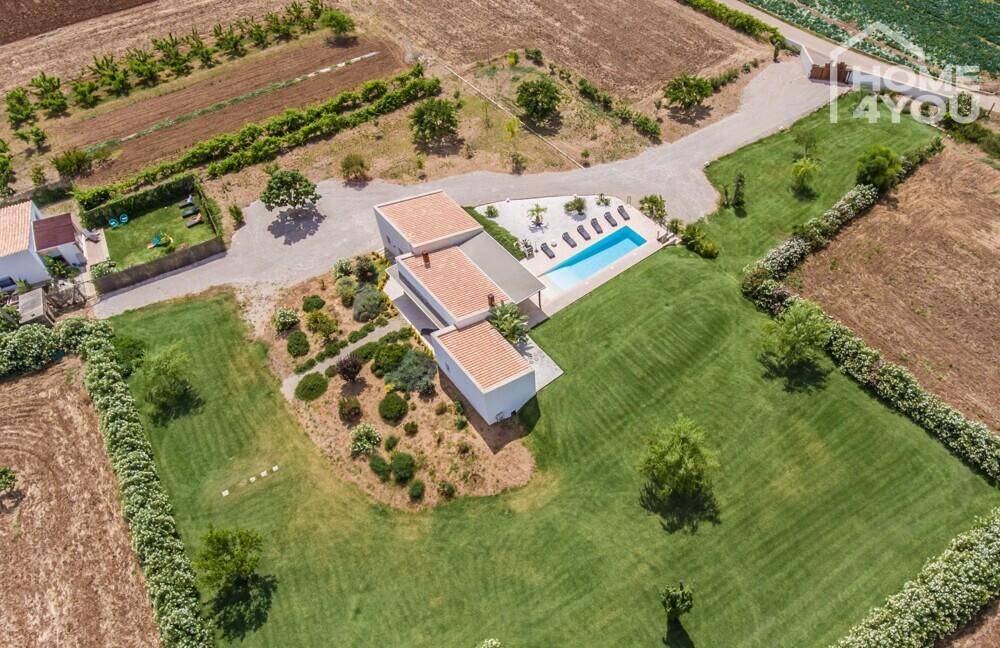 Detaillierte Luftaufnahme des Anwesens mit moderner Architektur, Pool und weitläufigen Grünflächen.